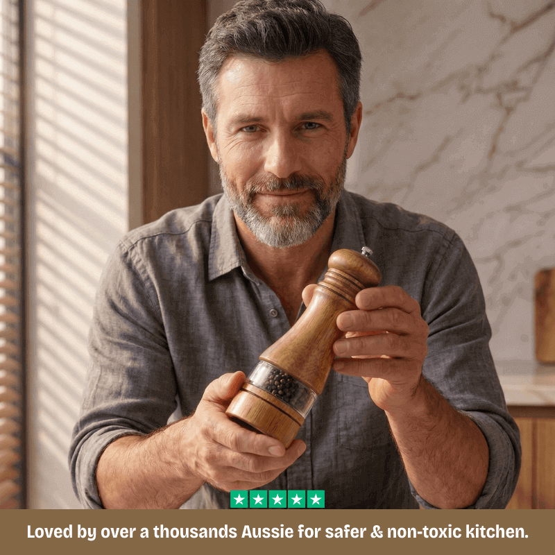 Man holding a wooden pepper grinder in a kitchen setting
