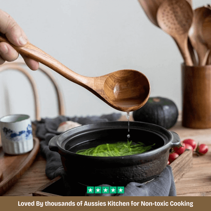 Person using a wooden spoon to serve green soup from a pot on a kitchen counter.
