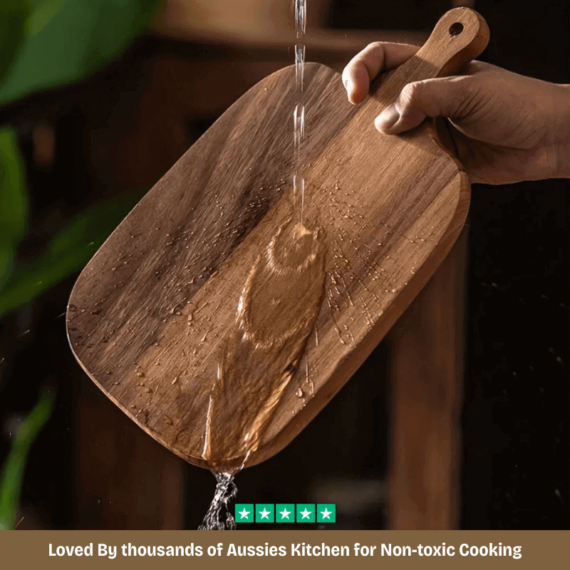 Wooden cutting board with water being poured onto it, with a hand holding it.