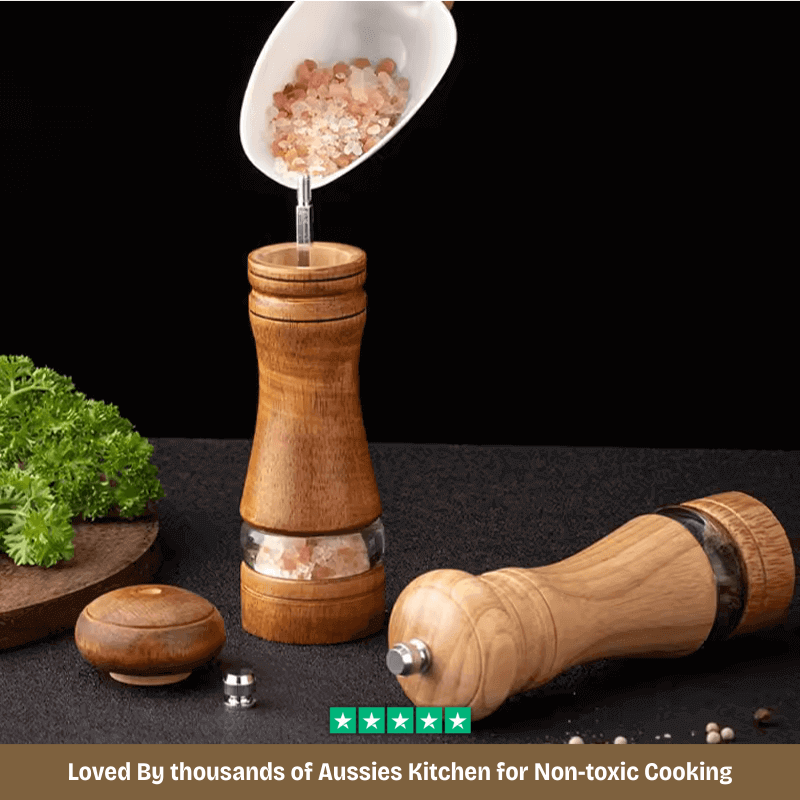 Wooden pepper grinder with salt shaker on a dark surface with text about non-toxic cooking.