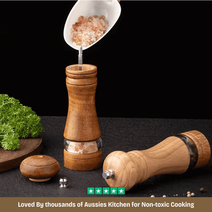 Wooden pepper grinder with salt shaker on a dark surface with text about non-toxic cooking.